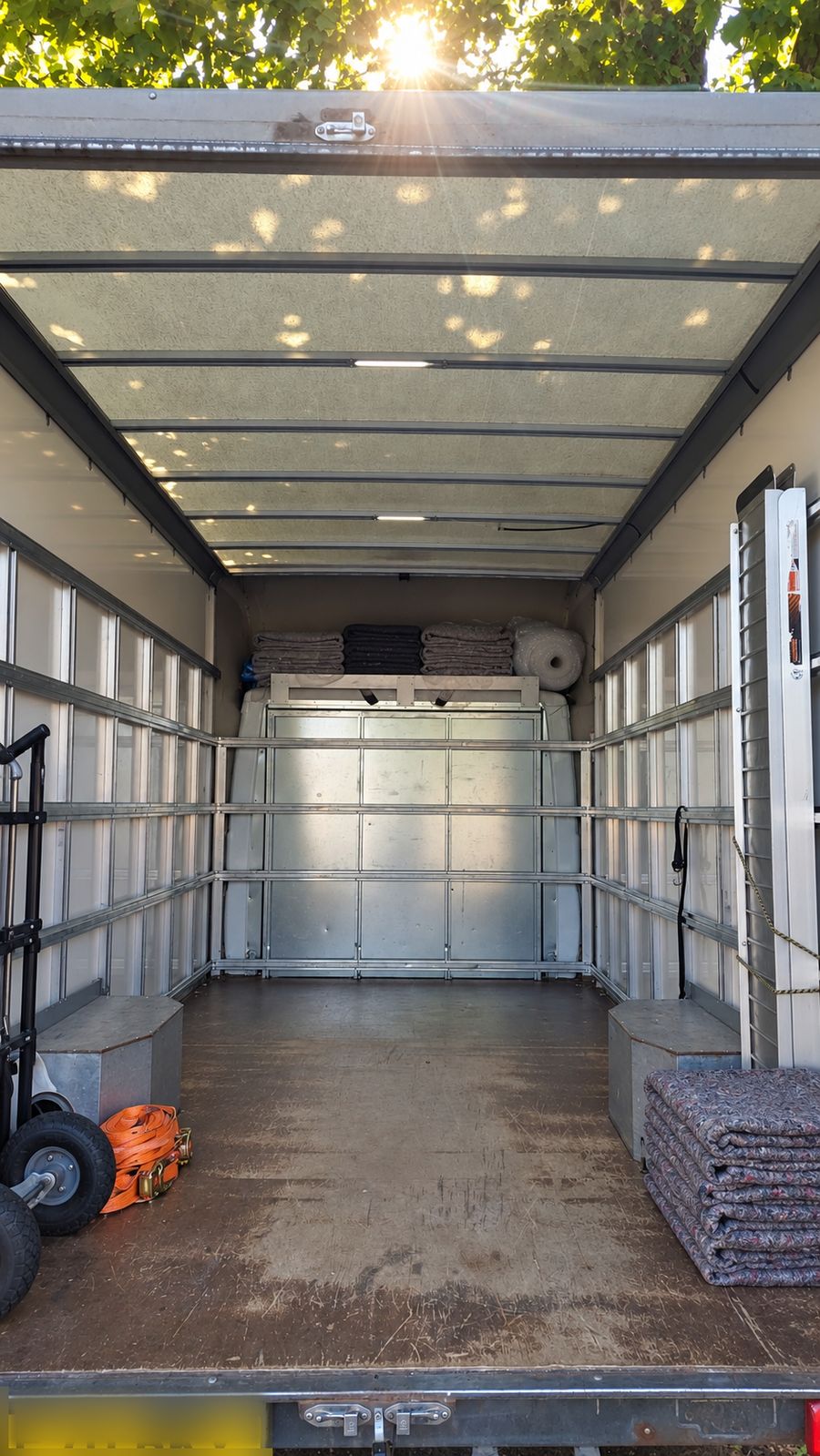 Clean van interior with folded moving blankets and straps ready